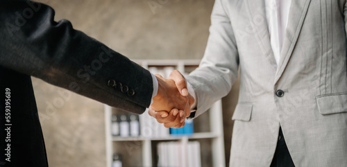 Two confident business man shaking hands during a meeting in the office, success, dealing, greeting and partner in sun light