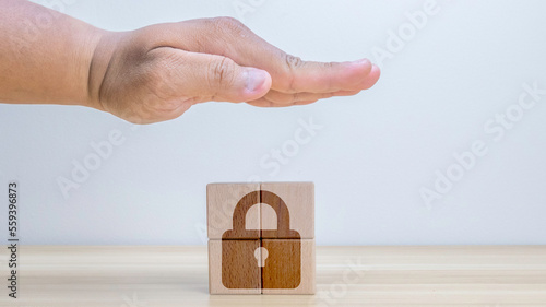 Personal data protection concept. Against digital cyber crime. Cyber security, secure access to information privacy on internet access. Hand showing to protect personal data and lockpad on wood cube. photo