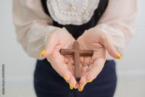 Fotografering Woman holding a wooden cross, Praying for God Religion.