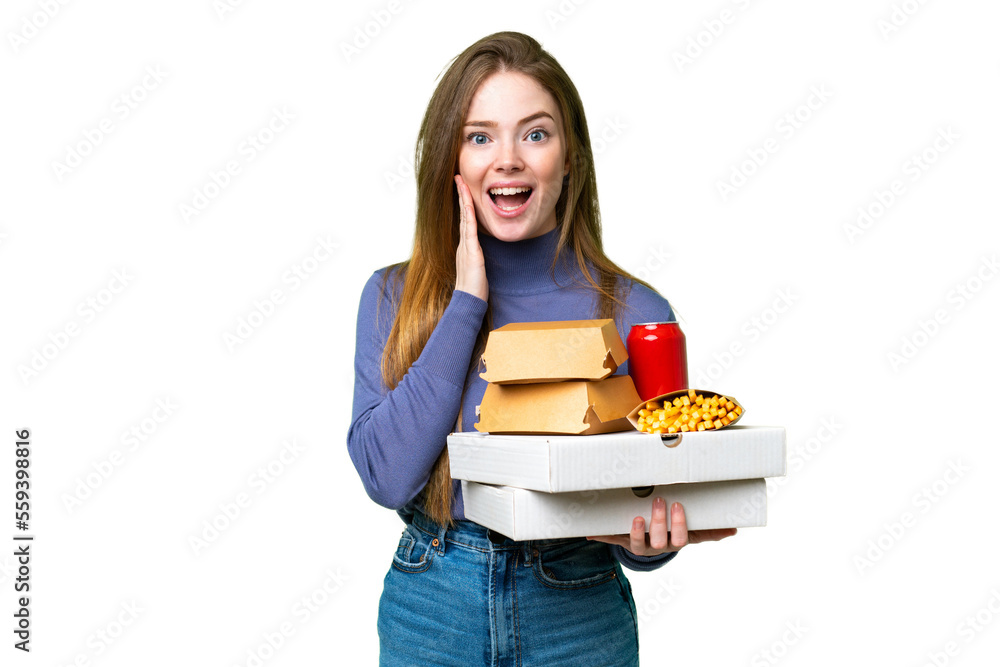 Young pretty woman holding pizzas and burgers over isolated chroma key background with surprise and shocked facial expression Young pretty woman holding pizzas and burgers over isolated chroma key background with surprise and shocked facial expression