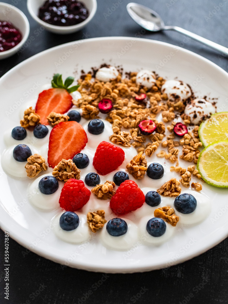 Yogurt with strawberries, blueberries, raspberries and muesli in bowl on wooden table
Yogurt with strawberries, blueberries, raspberries and muesli in bowl on wooden table