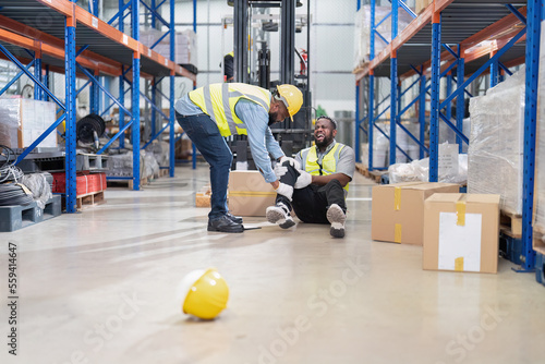 African american working in warehouse got accident from carry box, forklift truck working near by