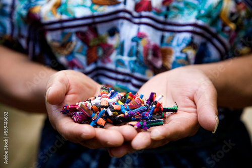 A woman holds a collection of prayer dolls she made in her house with the support of a local co-op. photo
