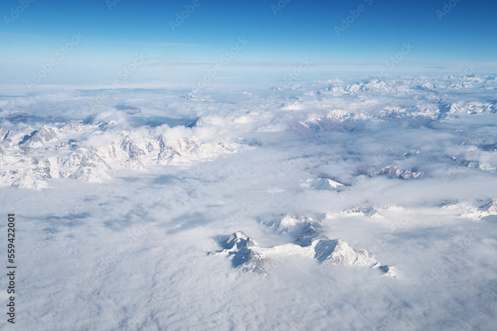 Mountain range and white clouds in blue sky at day.