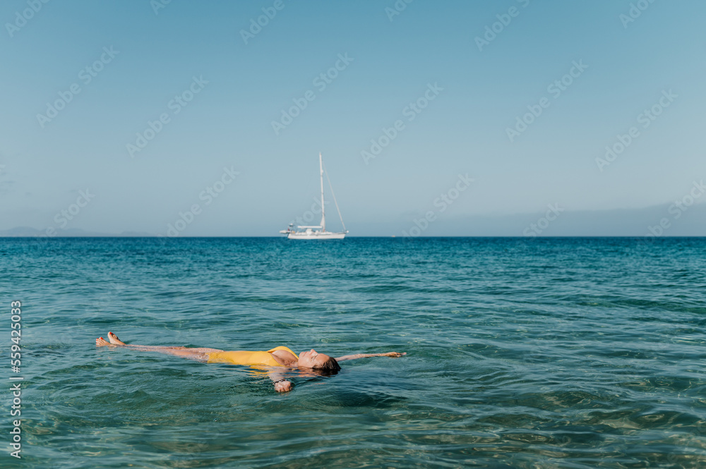 Woman floating on back in sea
