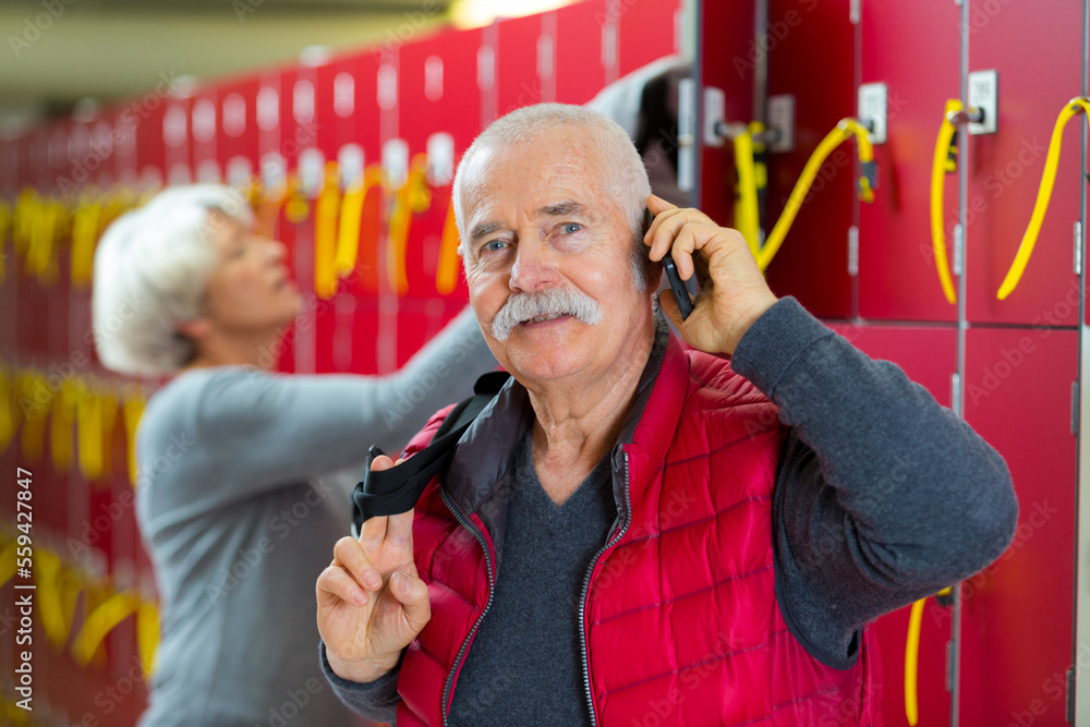 elderly man talking on the phone in the locker room