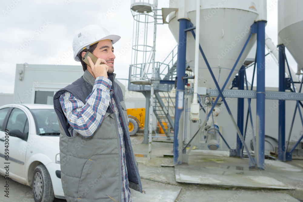 man using phone outdoors a natural gas factory