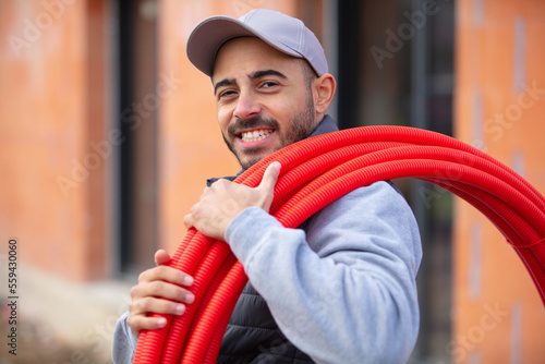 a plumber holding plastic pipes photo