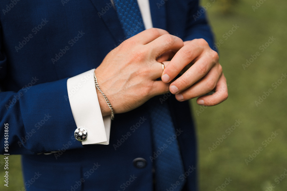 the groom adjusts the ring on his hand