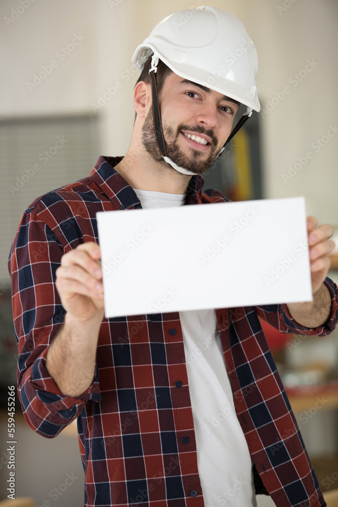 builder in a helmet showing a blank banner builder in a helmet showing a blank banner