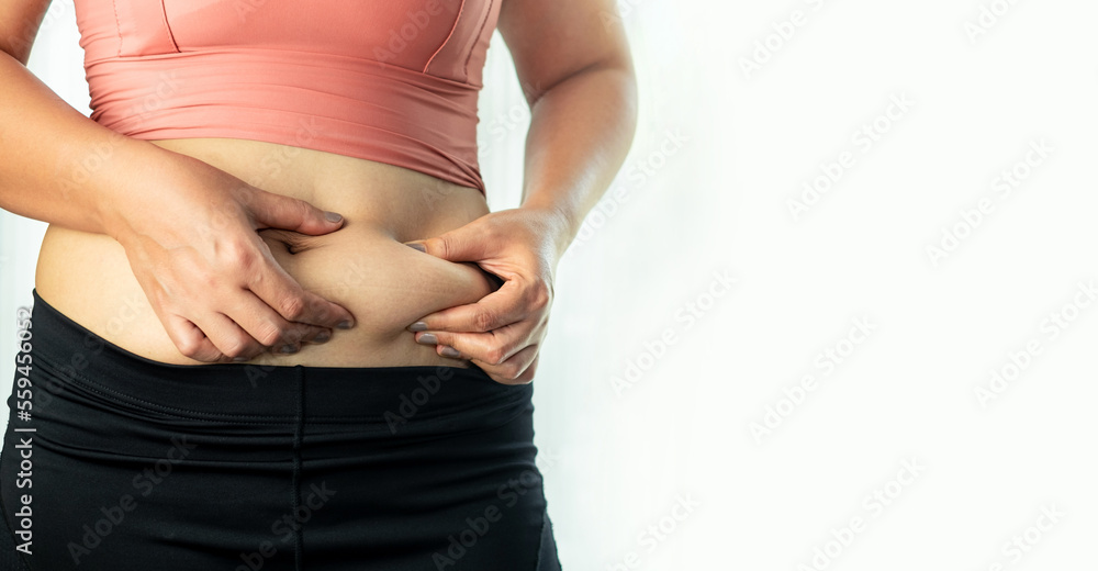Body care concept : Woman's hand pinching her excess belly fat, Fat unhealthy woman cellulite body isolated on white background Body care concept : Woman's hand pinching her excess belly fat, Fat unhealthy woman cellulite body isolated on white background