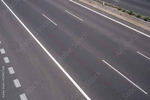 Road markings, solid lines and dashed lines, marking different lanes, on the dark asphalt floor of a highway. Tenerife, Canary Islands, Spain. © Jess