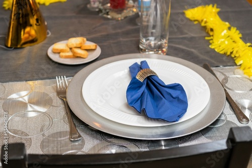 Elegant table set for a festive dinner in a restaurant. White plate, napkin and glassware.