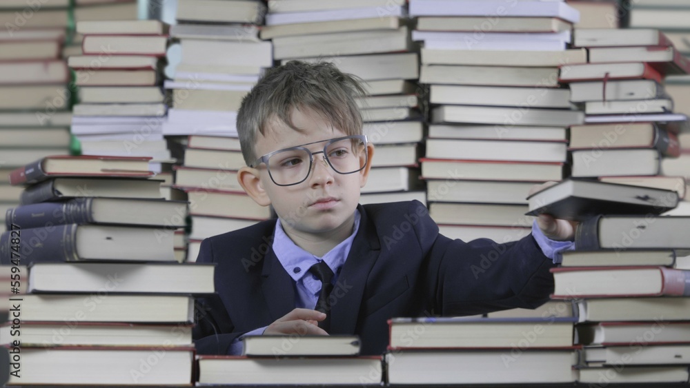 Boy with big eyeglasses looking in a book, close and open book, education Boy with big eyeglasses looking in a book, close and open book, education