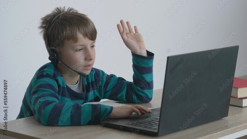 Little child with headphones look at laptop, talk and smile, internet connection Little child with headphones look at laptop, talk and smile, internet connection