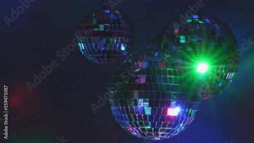 Mirror disco balls spinning and glittering colorful lights in the dark