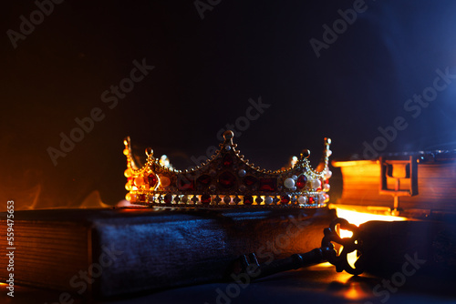 A golden crown, an old book, a key and old casket on a dark background. Panoramic view of the fog. Layout for your logo. A horizontal banner with a place to copy the cover image of a popular website.