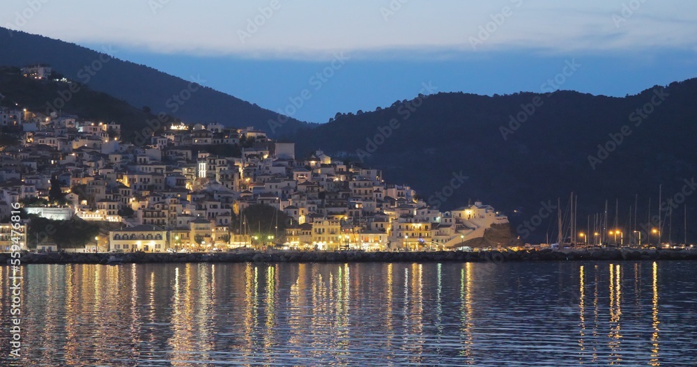 Beautiful Greece Skopleos town reflected in sea water, magical night landscape
