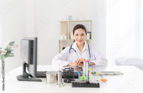 asian female doctor rest in her office, she reading and order treatment process on patient chart, she sitting and smile in hospital