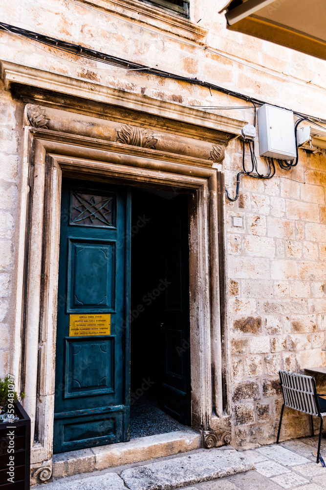 Naklejka premium Open door of a building on a street in the old town of Dubrovnik. Croatia.
