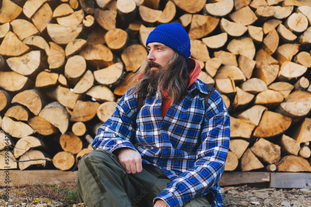 Man hiker hiking in mountain forest wearing cold weather accessories, wind jacket and backpack for camping outdoor. Guy portrait lifestyle.