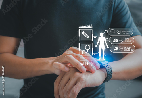 Fototapeta Naklejka Na Ścianę i Meble -  Concept of The technology to check health with smart watch. Futuristic smart watch technology male looking at watch checking health. holographic icon user interface.
