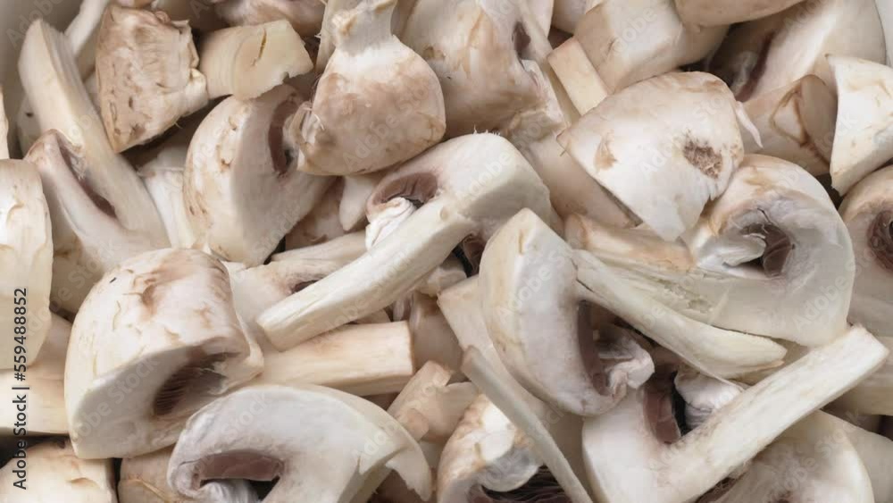 Large number of chopped mushrooms are on plate. On top of pile of mushrooms fall pieces of champignons. Slow motion of fall. Cooking food beautiful footage. Large number of chopped mushrooms are on plate. On top of pile of mushrooms fall pieces of champignons. Slow motion of fall. Cooking food beautiful footage.