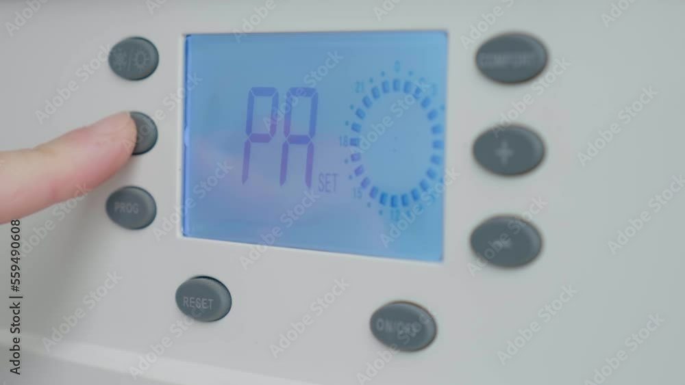 Hand adjust gas boiler control panel for comfort home heating and hot water. Concept of energy saving and heat conservation Hand adjust gas boiler control panel for comfort home heating and hot water. Concept of energy saving and heat conservation