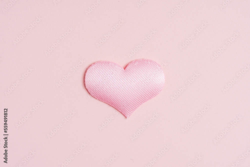 Background pink heart on peach colored paper.