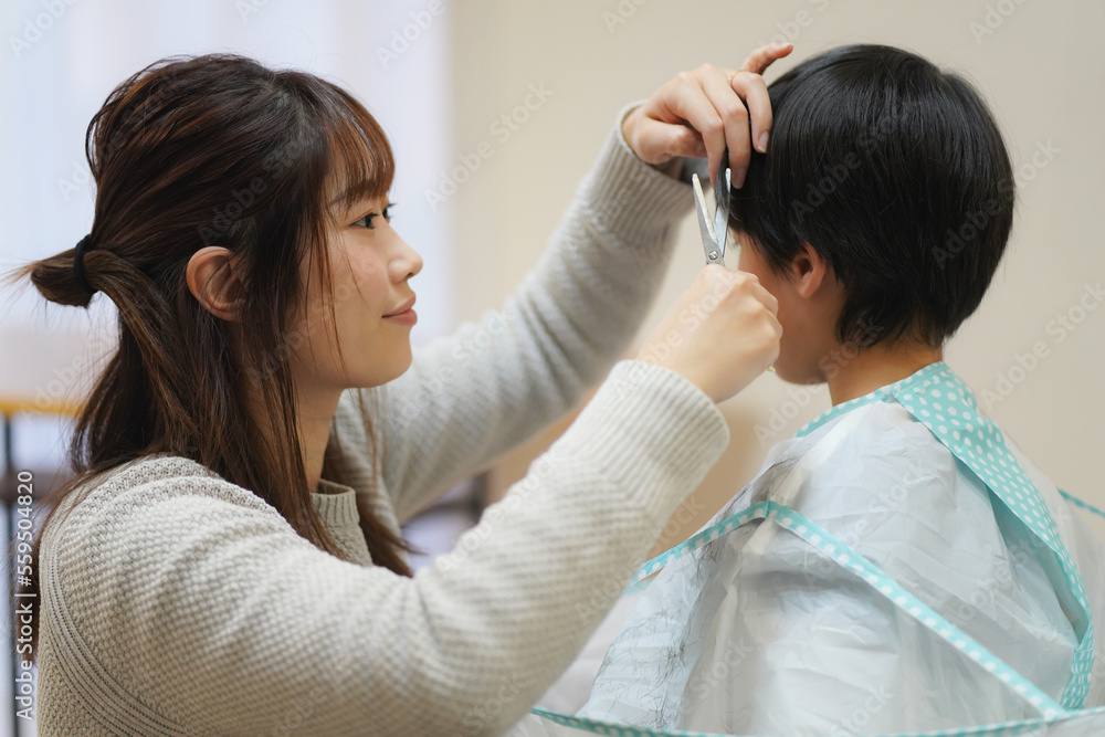 Obraz premium 子供の髪を切る母親