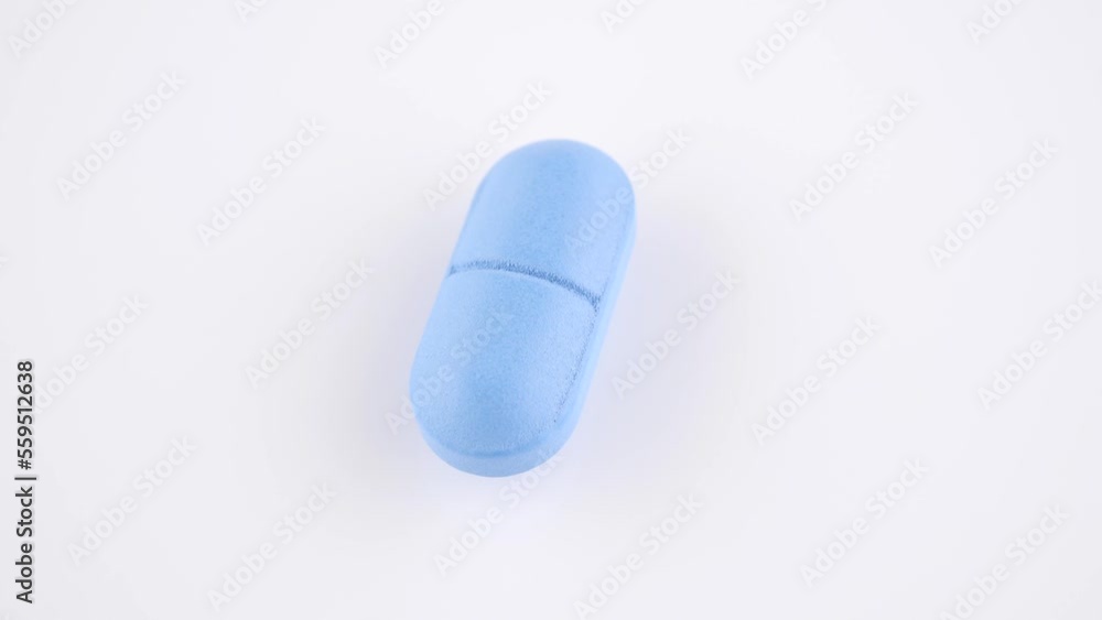 Blue pill isolated on white background, rotation. Pharmaceutical production
