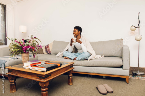 Canvastavla person sitting on a sofa and drinking coffee