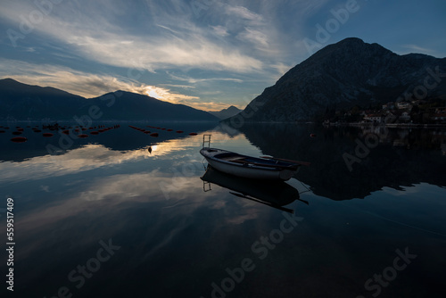 View of kotor bay, beautiful reflection with blue cloudy sky and boats and houses on shore © Aytug Bayer