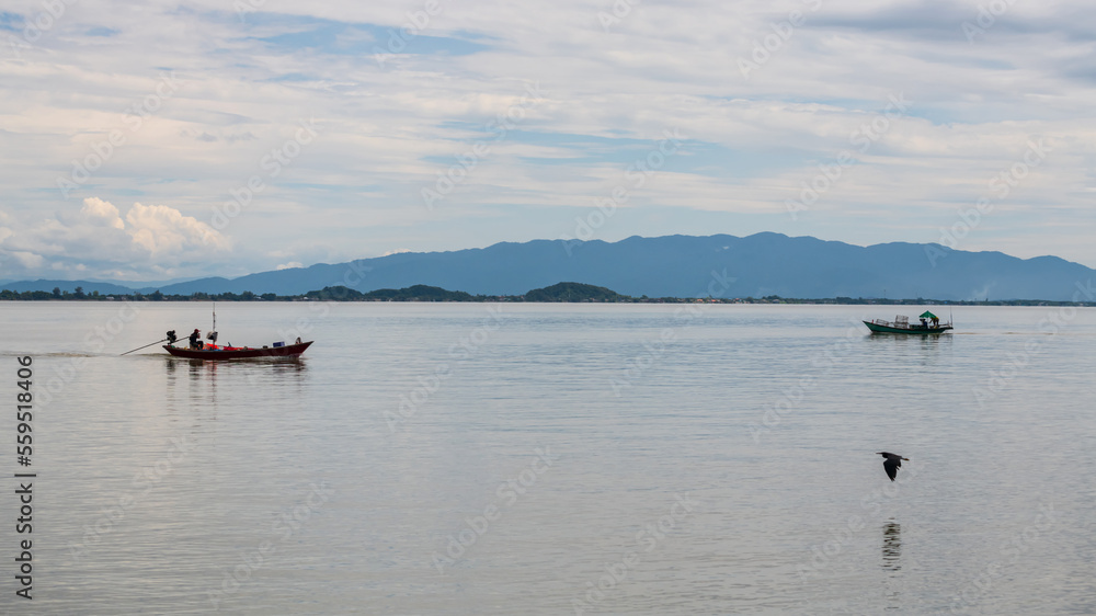 Fishermen sail boats with flying bird in Kung Krabaen, Chanthaburi