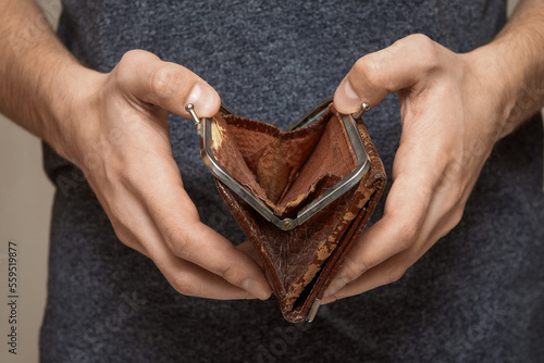 An empty wallet in the hands of a young man, the concept of bankruptcy photo