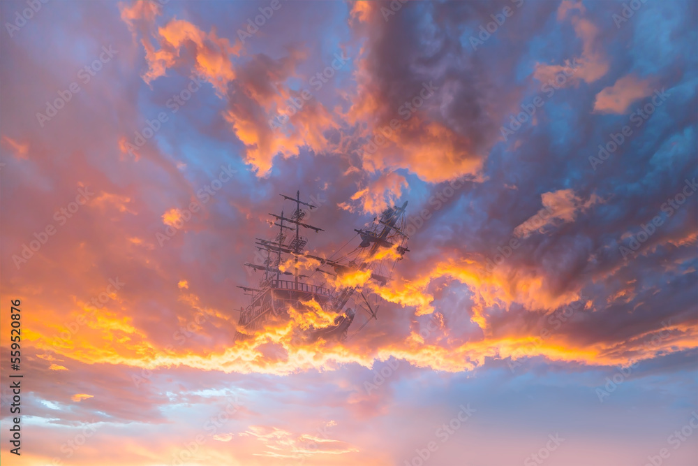 Flying old sailing ship at the among the sunset clouds