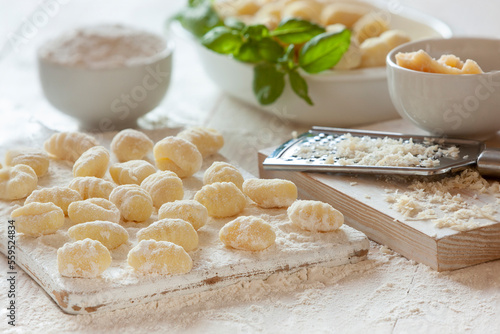 Traditional homemade raw italian potato gnocchi on white wooden background photo