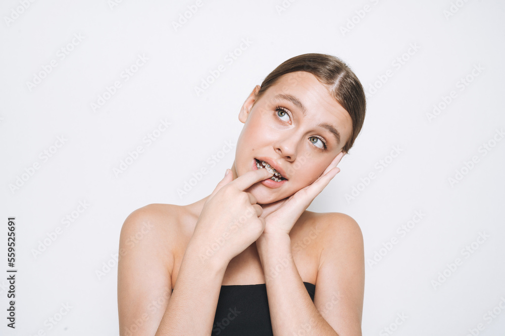 Beauty portrait of funny young girl with fresh skin, teenager with braces on teeth on white background isolated Beauty portrait of funny young girl with fresh skin, teenager with braces on teeth on white background isolated