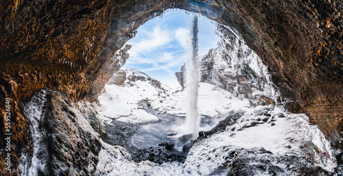 Kvernufoss waterfall, Iceland. Icelandic winter landscape. High waterfall and rocks. Snow and ice photo