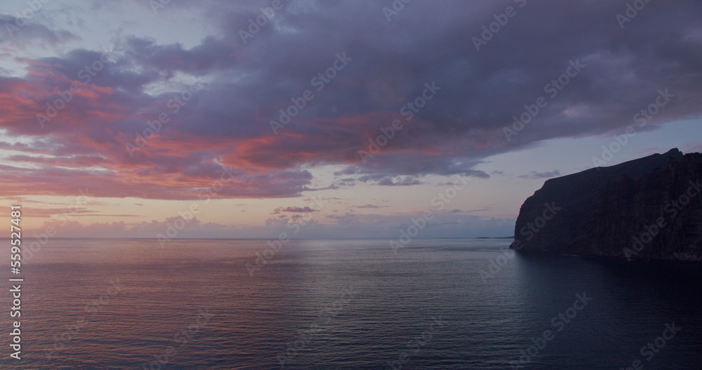 Los Gigantes cliffs at sunset. Tenerife, Canary Islands, Spain. Volcanic rocky beach. Pink night clouds on sky.