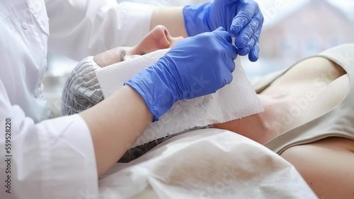Cosmetologist dries face with paper towels in spa salon.