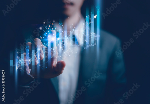 Fototapeta Naklejka Na Ścianę i Meble -  Businessman holding a graph goal of business Investor,analysis economic and calculates financial data and target for long-term investments and profitability in future on digital data system manager..