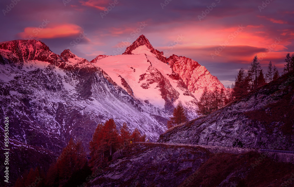Incredible scenery of European Alps in during sunset. Grossglockner peak glowing in sunlight with perfect colorful sky. Grossglockner High Alpine  is a most popular place of travel.