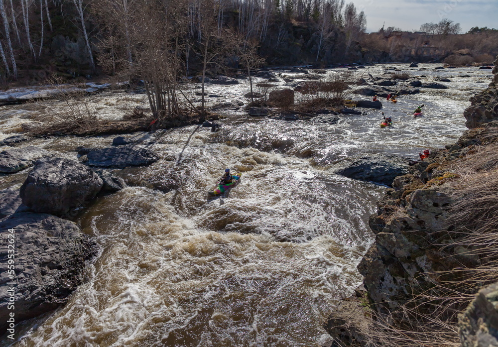 Obraz premium Water sports competitions on kayaks on a full-flowing river in spring