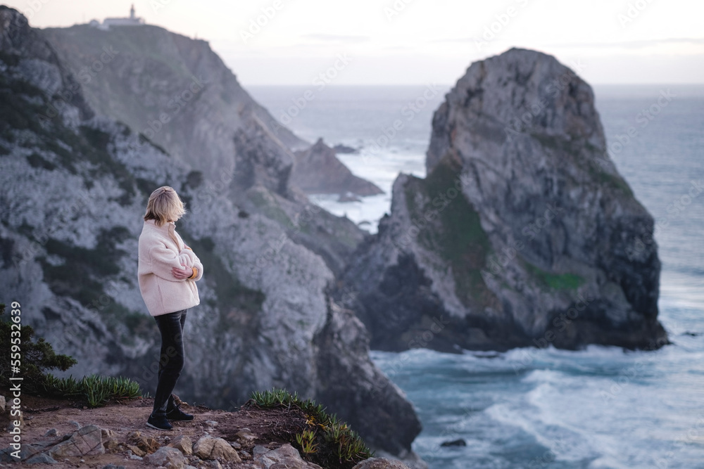 Woman on the Atlantic cliffs near Sintra, Portugal.