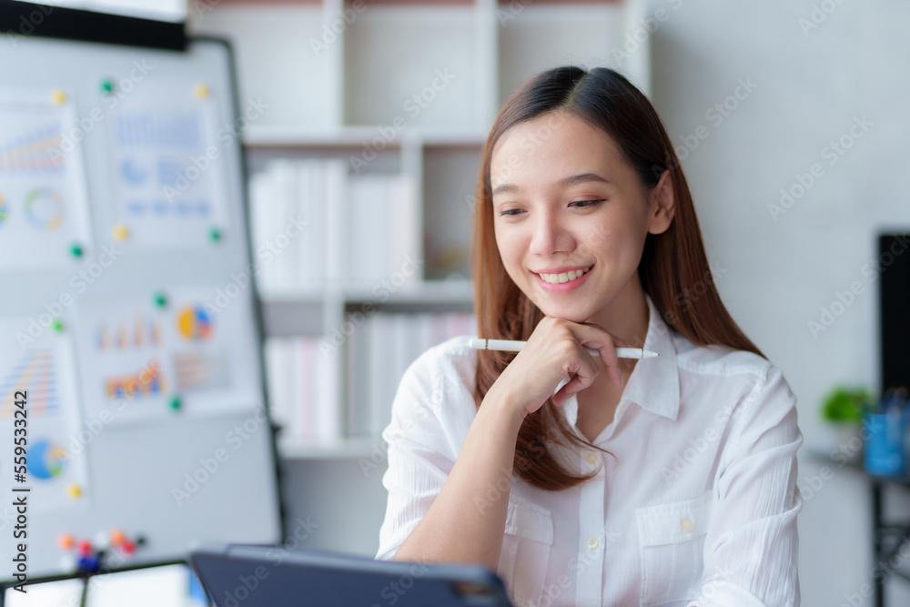 Beautiful Asian businesswoman using her laptop enjoying work, taking notes, reviewing work done. Beautiful Asian businesswoman using her laptop enjoying work, taking notes, reviewing work done.