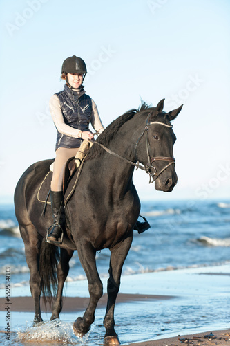 Young Lady riding horseback at wavy seaside/ocean coast © AnnaElizabeth
