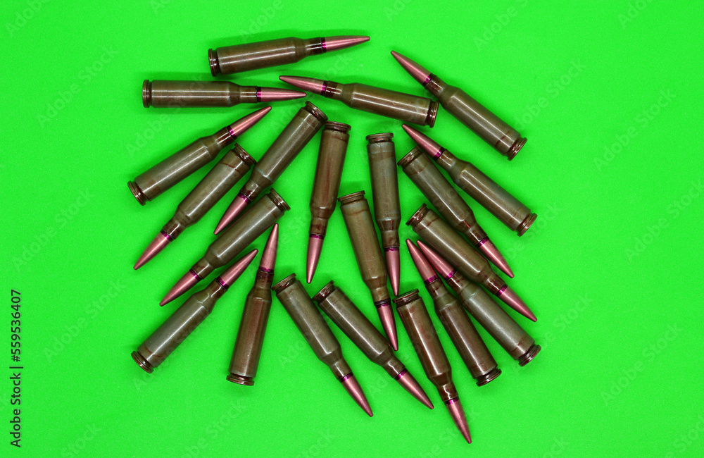 Live ammunitions with copper bullets scattered on a green top view
Live ammunitions with copper bullets scattered on a green top view