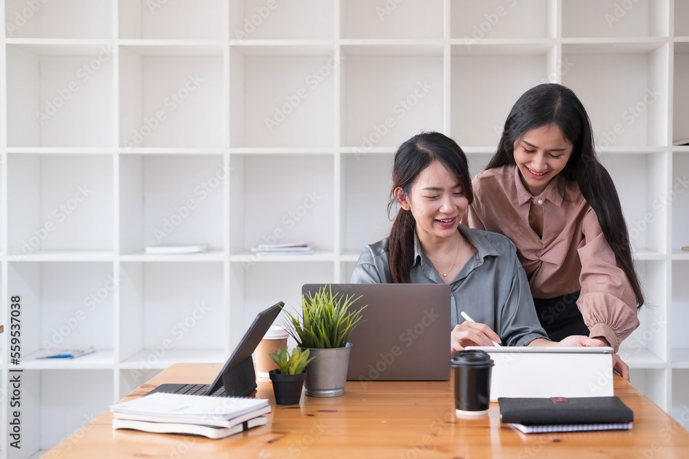 Two young Asian business woman talk, consult, discuss working with new startup project idea presentation analyze plan marketing and investment in the office. Two young Asian business woman talk, consult, discuss working with new startup project idea presentation analyze plan marketing and investment in the office.