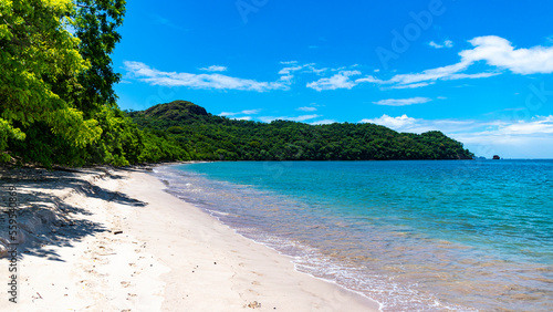 Fototapeta Naklejka Na Ścianę i Meble -  panorama of the famous conchal beach over the pacific in costa rica; paradise beach with turquoise water and green hills in the background